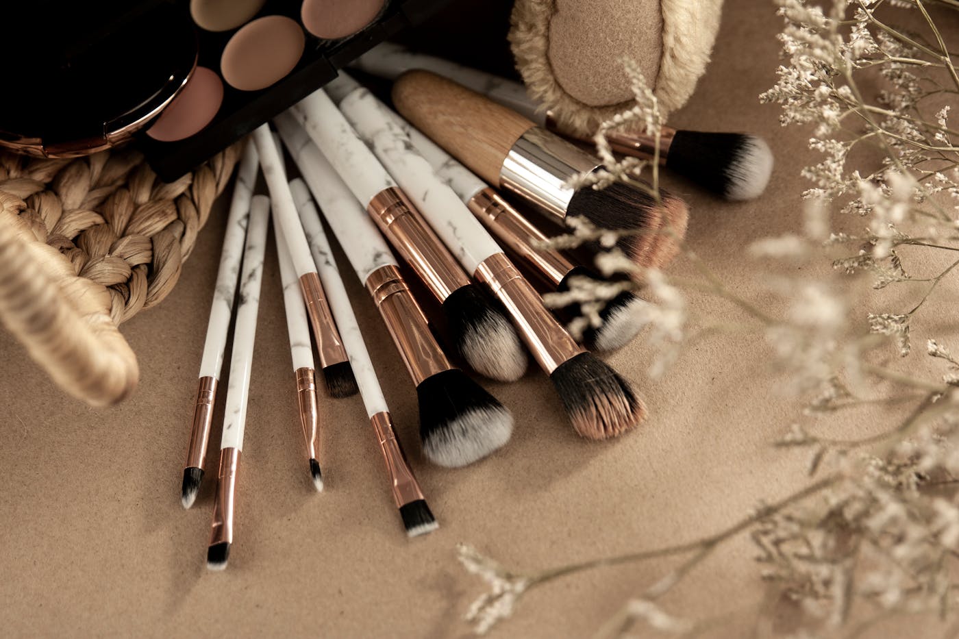 Brochas y productos de maquillaje sobre fondo beige